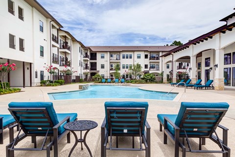 Pool along with chairs at The Laurel at Vintage Park 55+ Apartments, Tomball, 77377
