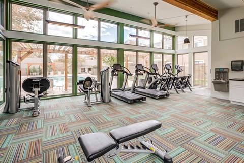 A gym with a variety of equipment including treadmills, weights, and exercise bikes at The Ranch at Bear Creek Apartments, Colorado, 80227