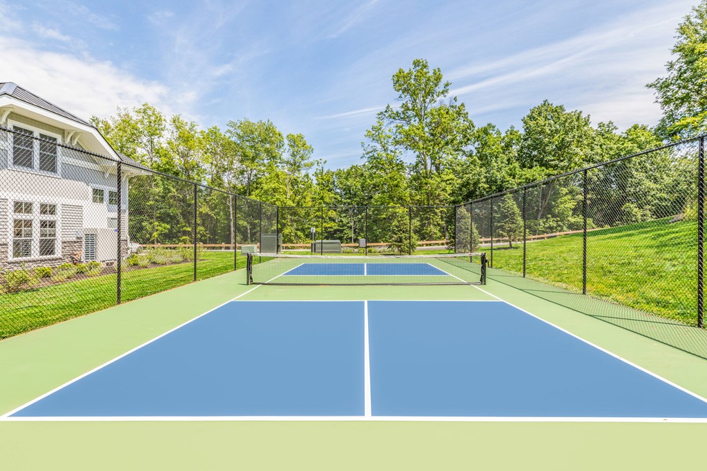 a tennis court with a house on the side of it