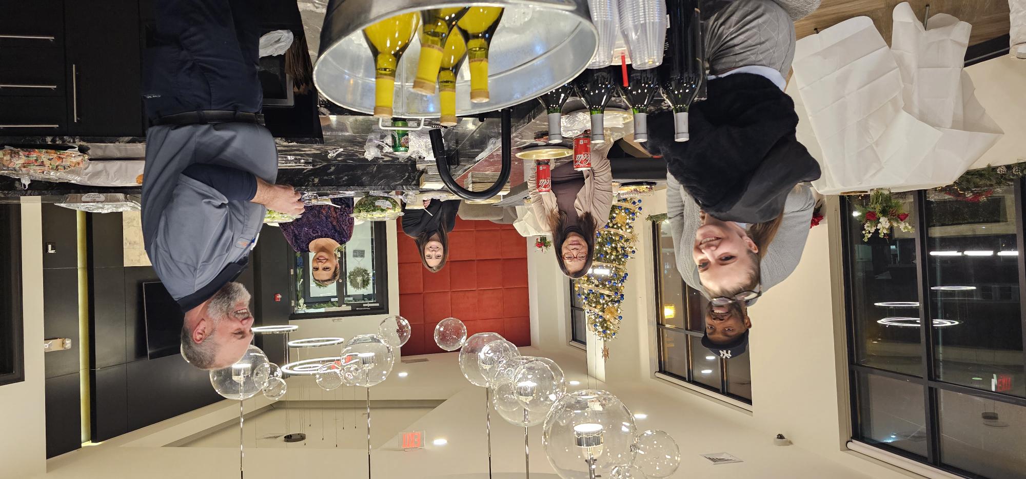 a group of men standing around a restaurant table with wine glasses at Metro 303, New York, 11550