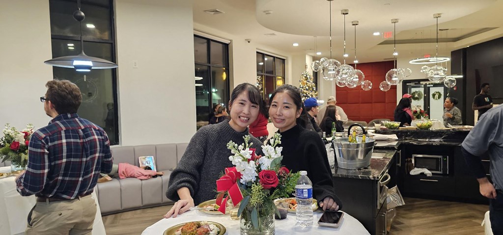 two women sitting at a table in a restaurant with flowers at Metro 303, New York, 11550