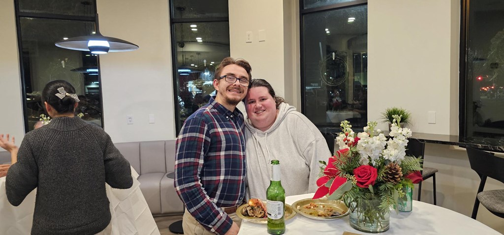 two people sitting at a table with a vase of flowers at Metro 303, New York, 11550