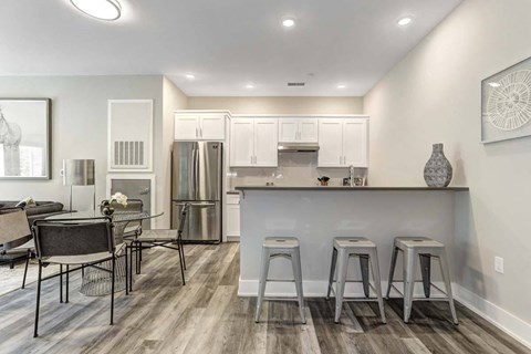 a kitchen and dining room with a bar and a refrigerator
