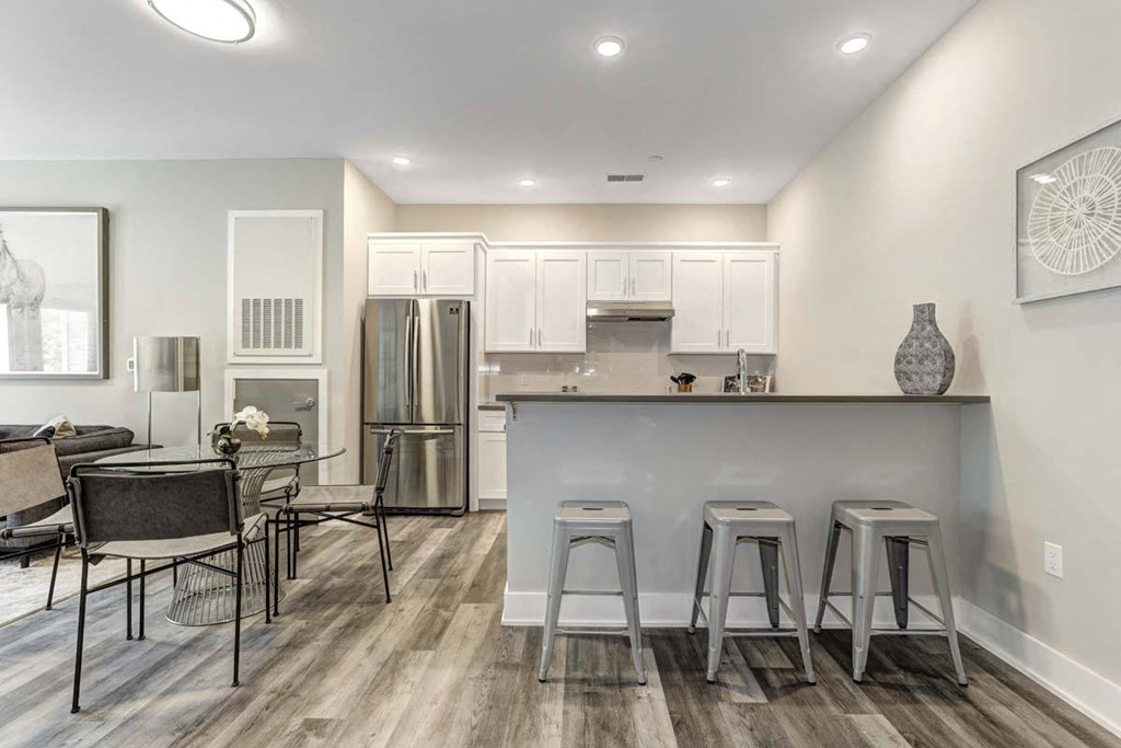 a kitchen and dining room with a bar and a refrigerator