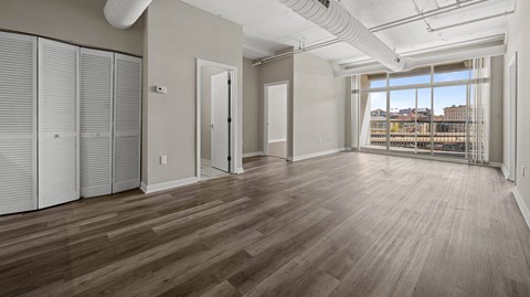 A large empty room with wooden floors and white walls.