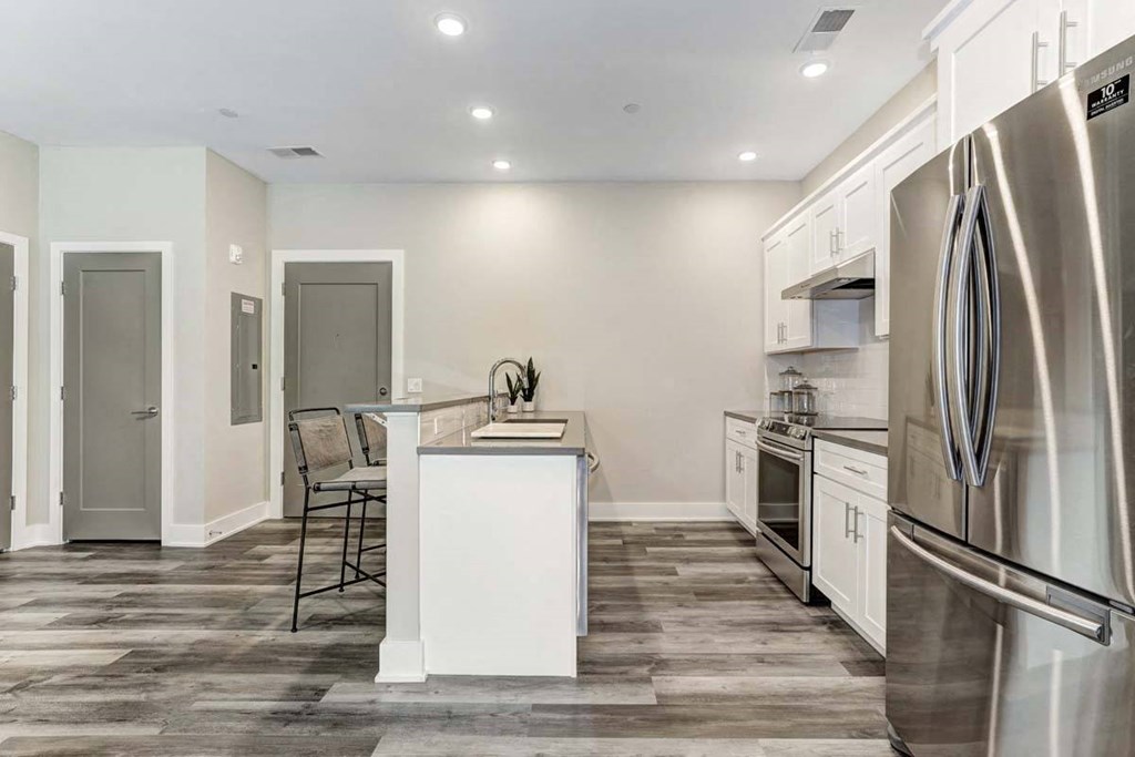 a kitchen with a center island and a stainless steel refrigerator