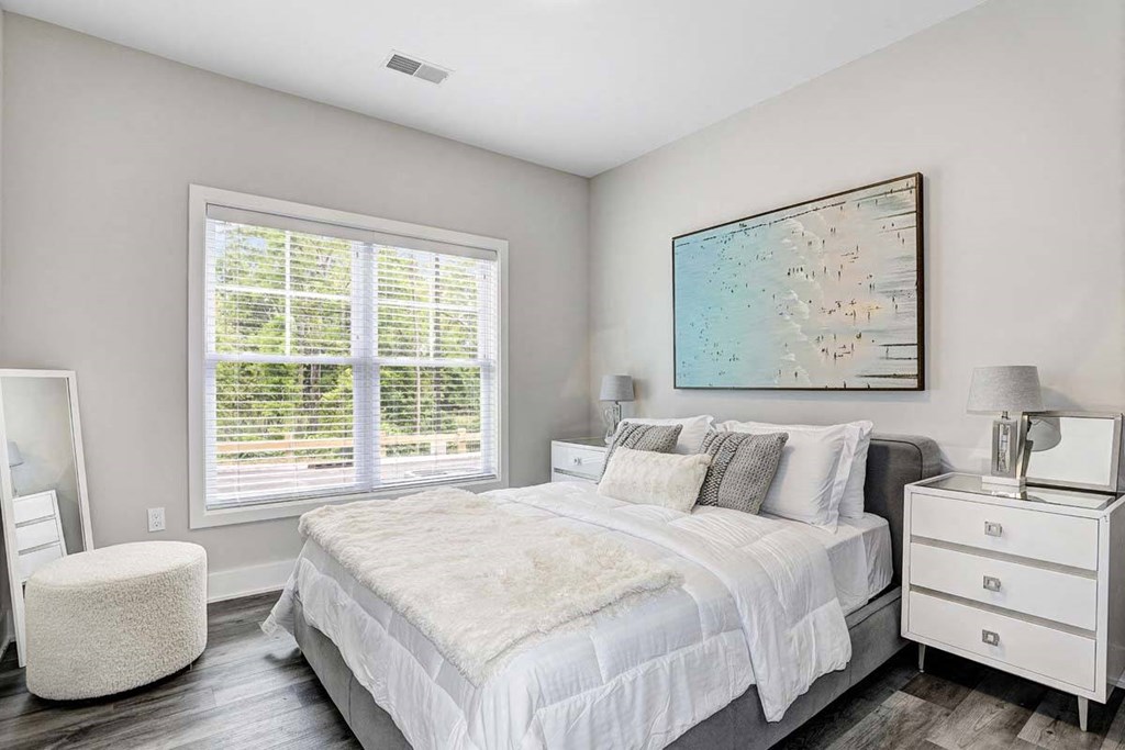 a bedroom with a bed and two windows