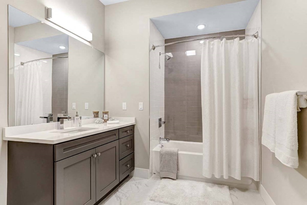 a bathroom with a shower and a sink and a mirror