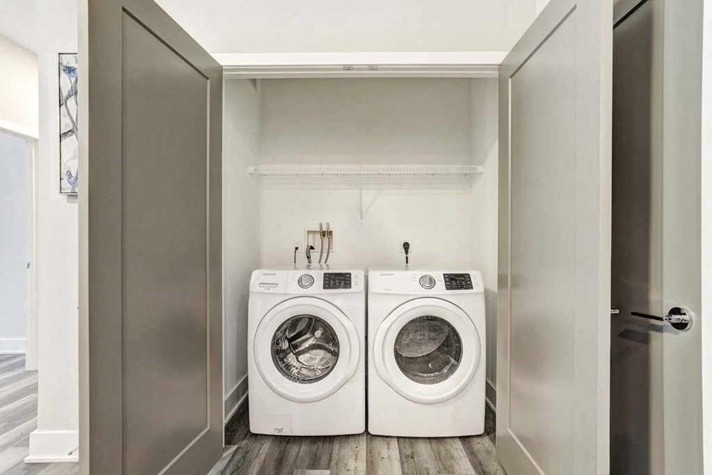 a white washer and dryer in a laundry room with a door