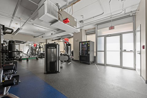 A gym with a variety of equipment including a treadmill, weights, and a television.