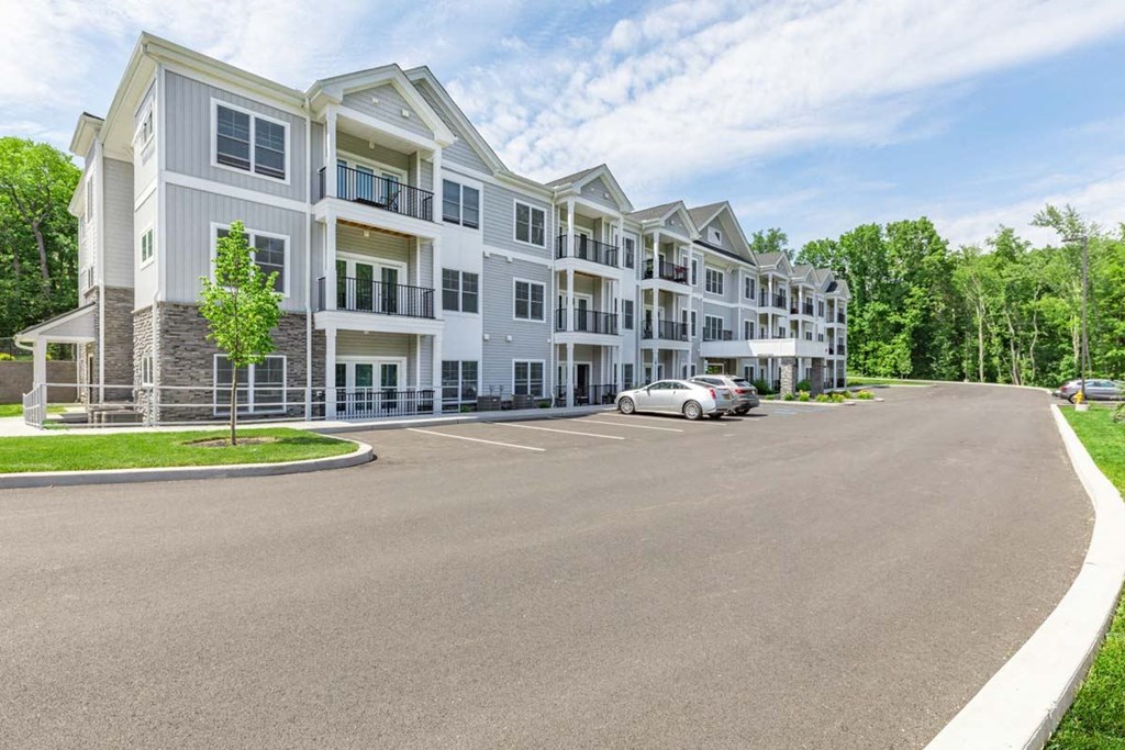 a large apartment building with a car parked in front of it
