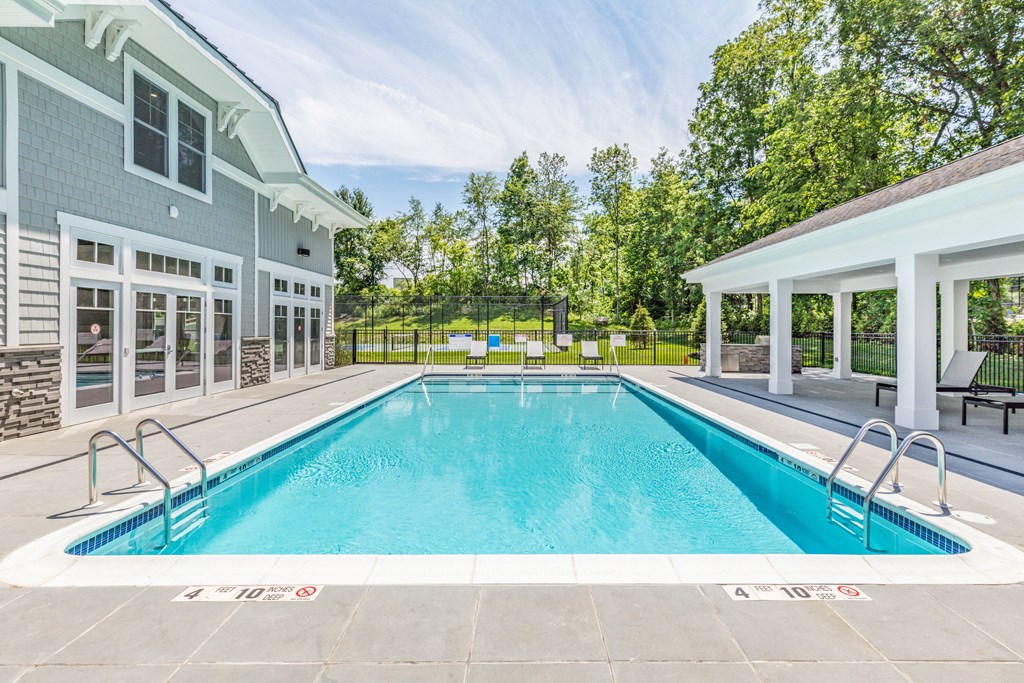 the pool is next to a house with a swimming pool