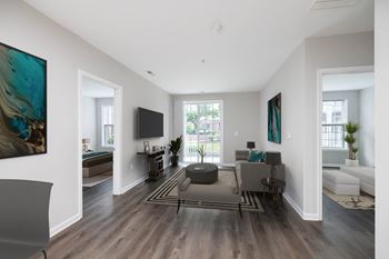 A modern living room with a grey sofa and a wooden floor.