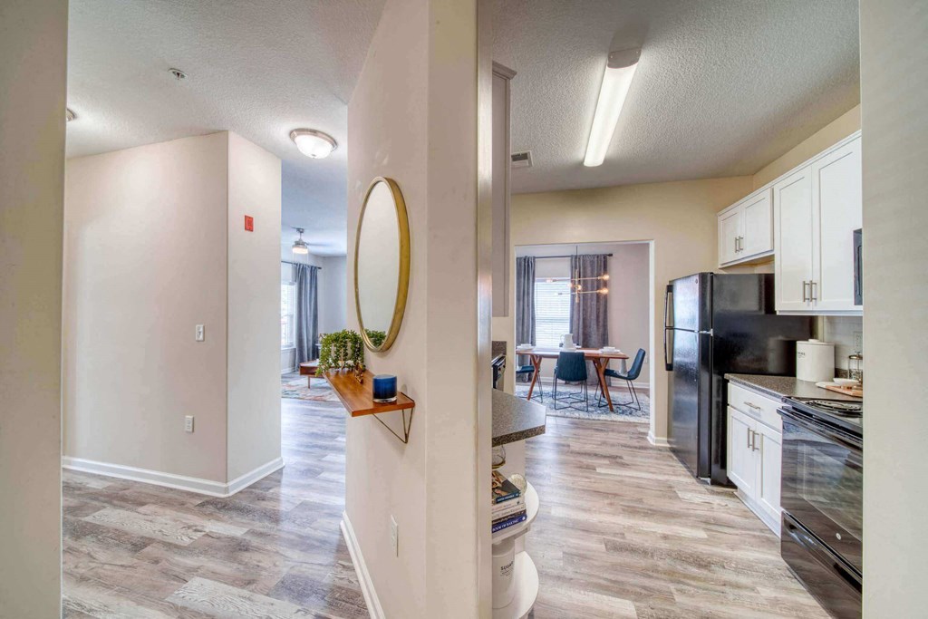 a kitchen and living room with a black refrigerator freezer and a black stove top oven at Meridian Obici, Virginia, 23434
