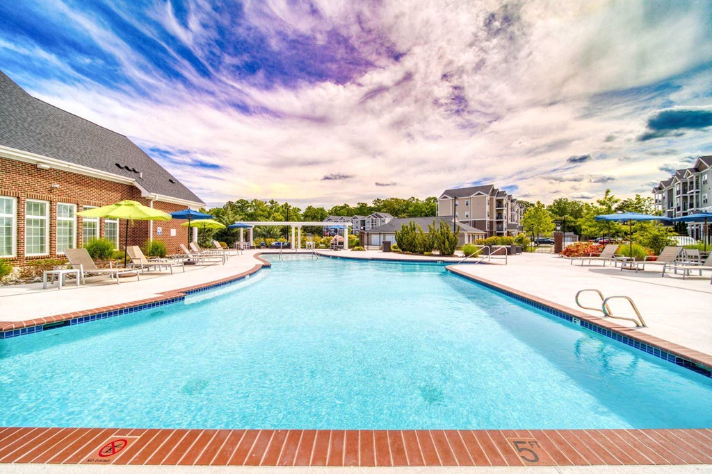 a swimming pool with lounge chairs at Meridian Obici, Suffolk, 23434