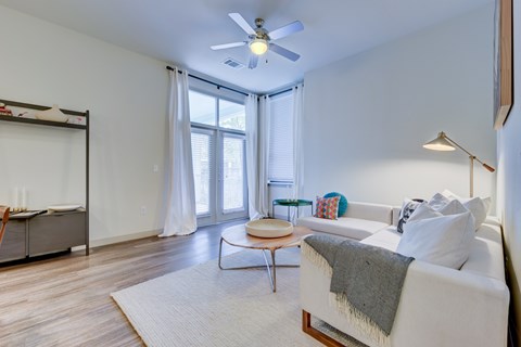 A living room with a white couch and a ceiling fan.