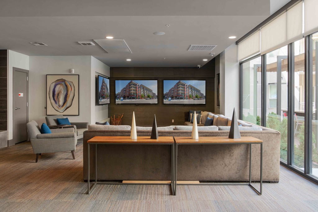 A modern office space with a large desk and a couch at Regatta Sloans Lake Apartments, Denver