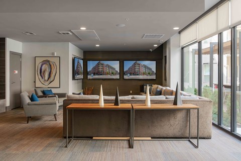 A modern office space with a large desk and a couch at Regatta Sloans Lake Apartments, Denver