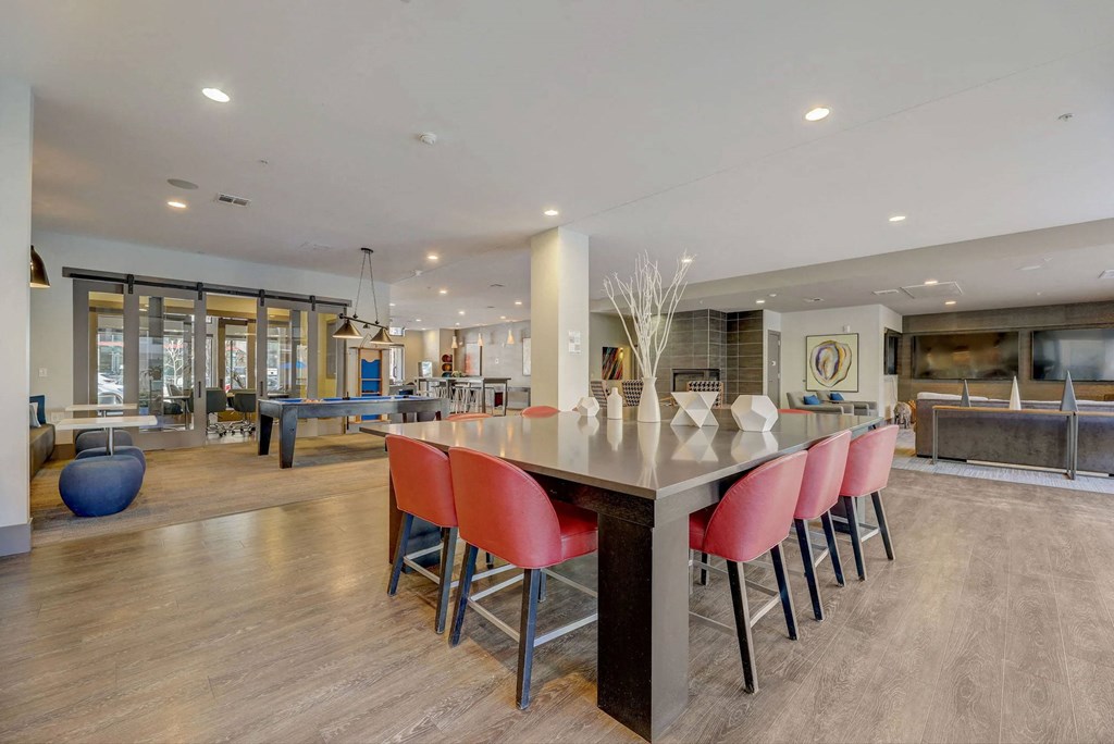 A modern kitchen with a long island and red chairs at Regatta Sloans Lake Apartments, Colorado, 80204