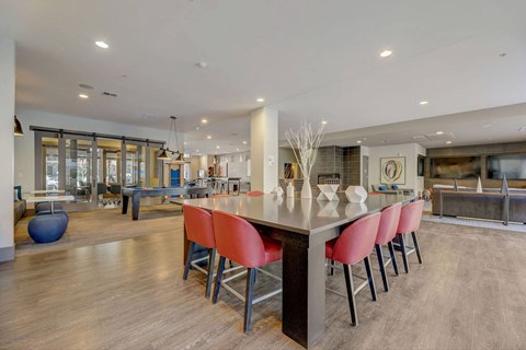 A modern kitchen with a long island and red chairs at Regatta Sloans Lake Apartments, Colorado, 80204