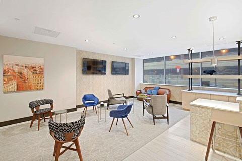 A living room with a large painting of a cityscape on the wall and a row of chairs in front of it.