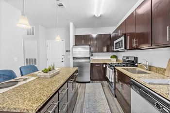 a kitchen with wooden cabinets and granite countertops  at Harbor Pointe, Bayonne, 07002