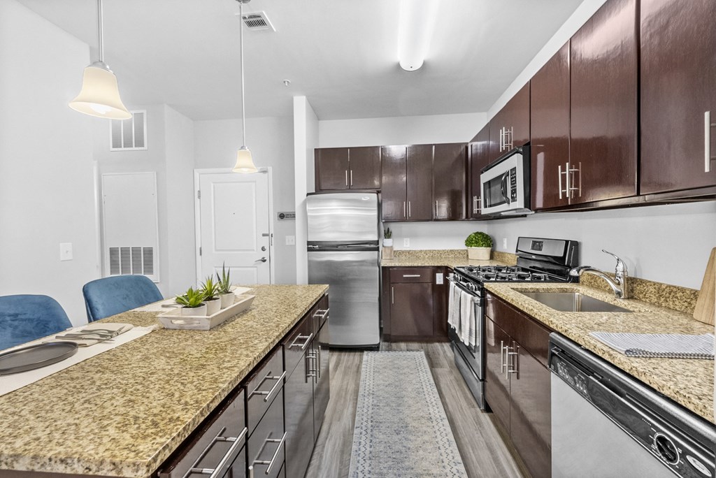 a kitchen with wooden cabinets and granite countertops at Harbor Pointe in Bayonne, NJ