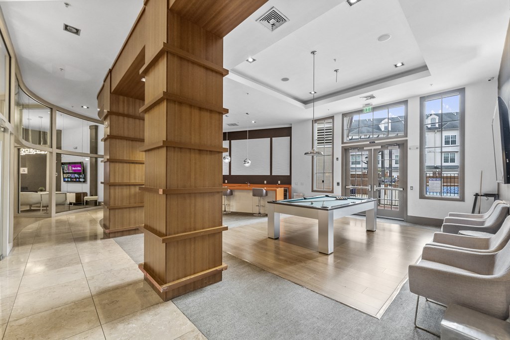 Hallway to Gym, Business Center, Game Room, and The Clubhouse with a pool table, entrance to outdoor pool, a bar and kitchen at Harbor Pointe, New Jersey, 07002
