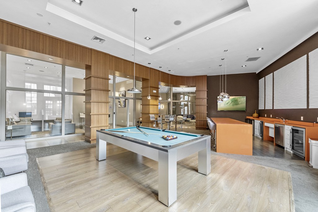 The Clubhouse with a pool table, entrance to outdoor pool, a bar and kitchen at Harbor Pointe, New Jersey, 07002