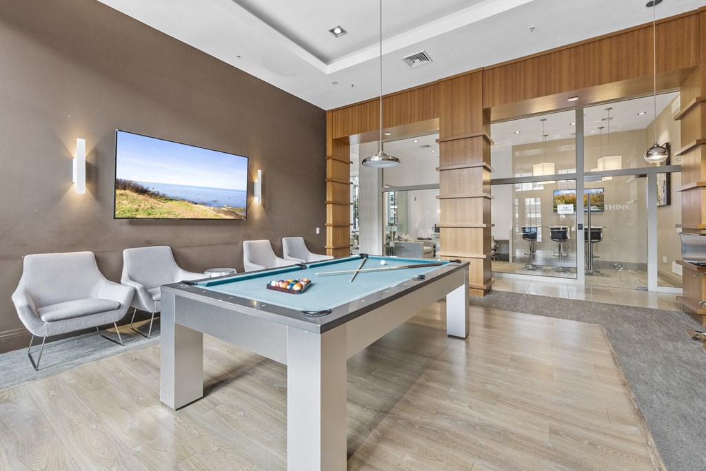 The Clubhouse with a pool table, entrance to outdoor pool, a bar and kitchen at Harbor Pointe, New Jersey, 07002