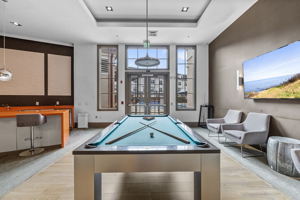 The Clubhouse with a pool table, entrance to outdoor pool, a bar and kitchen at Harbor Pointe, New Jersey, 07002