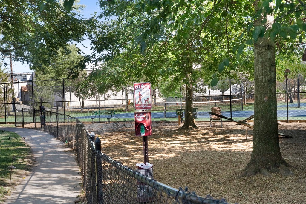 a private dog park with a tennis court in the background and trees in the foreground  at The Lena, Raritan, NJ, 08869