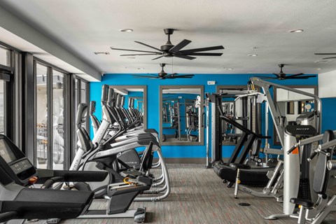 A gym with treadmills, weights, and a fan at Regatta Sloans Lake Apartments, Denver, Colorado