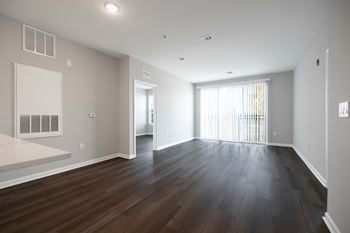 A large empty room with wooden floors and white walls. at Harbor Pointe, Bayonne, New Jersey
