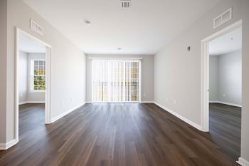 A large empty room with wooden floors and white walls. at Harbor Pointe, Bayonne, New Jersey
