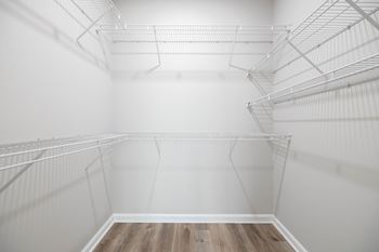 Empty white shelves in a room with wooden flooring.