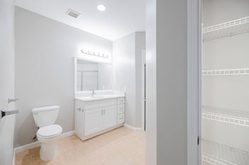 A white bathroom with a toilet, sink, and medicine cabinet.