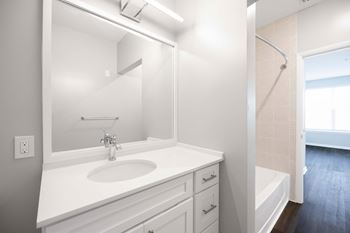 A white bathroom with a sink, mirror, and bathtub. at Harbor Pointe, New Jersey