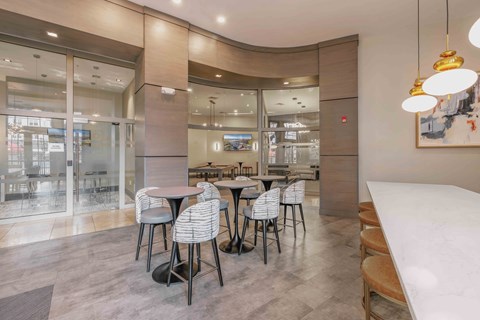 A modern dining area with a glass wall and a curved ceiling at Harbor Pointe Apartments, Bayonne, NJ, 07002