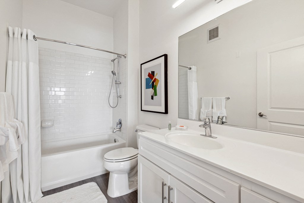 a bathroom with a bathtub toilet and sink at Metro 303, Hempstead, NY 11550