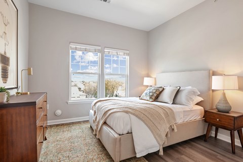 a bedroom with a bed and two windows at Metro 303, Hempstead, NY