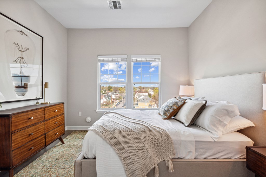 a bedroom with a bed and a dresser at Metro 303, Hempstead