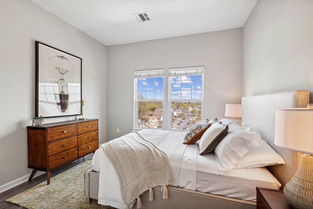 a bedroom with a bed and a dresser at Metro 303, Hempstead, NY