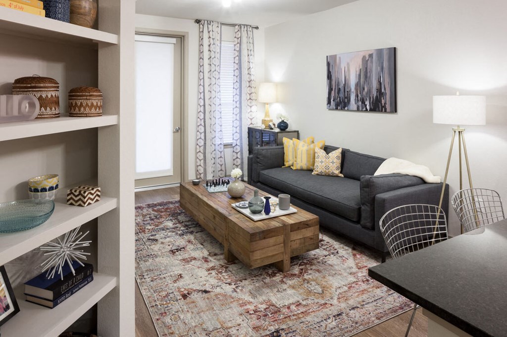 A living room with a grey couch and a wooden coffee table at Regatta Sloans Lake Apartments, Denver, CO, 80204