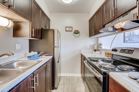 A kitchen with a stove top oven and a refrigerator.