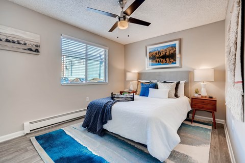 A bedroom with a bed, a ceiling fan, and a rug at Mountain Vista Apartments, Lakewood, Colorado
