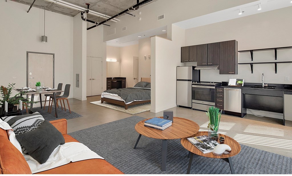 A modern living room with a kitchen area in the background at RiDE at RiNo Apartments, Colorado