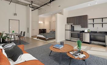 A modern living room with a kitchen area in the background. at RiDE at RiNo Apartments, Denver