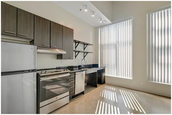 A modern kitchen with stainless steel appliances and wooden cabinets. at RiDE at RiNo Apartments, Colorado, 80216