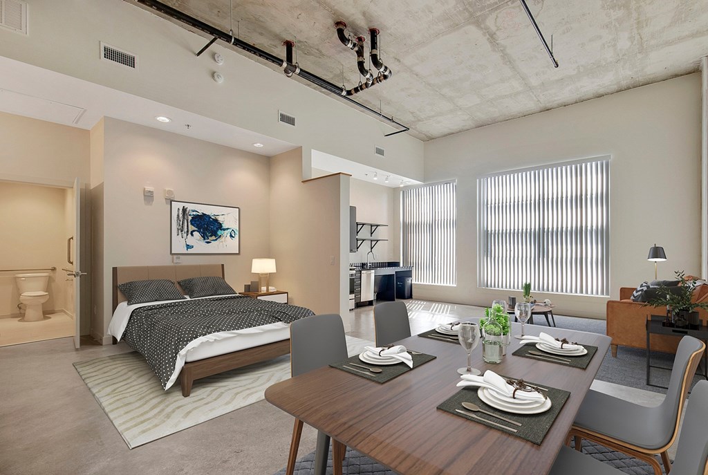A modern bedroom with a large bed and a dining area with a table set for four at RiDE at RiNo Apartments, Denver 80216